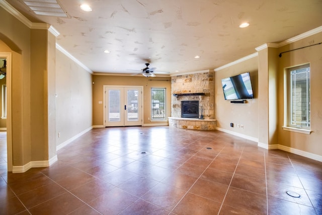 unfurnished living room with tile patterned flooring, crown molding, ceiling fan, and a fireplace