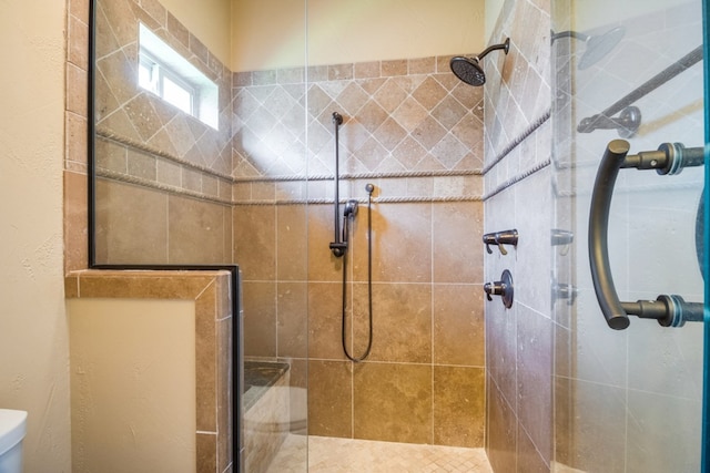 bathroom featuring toilet and a shower with door