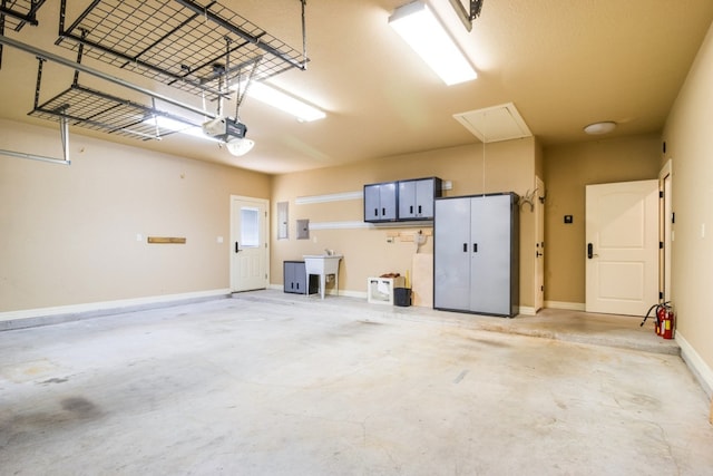 garage featuring a garage door opener, electric panel, and sink