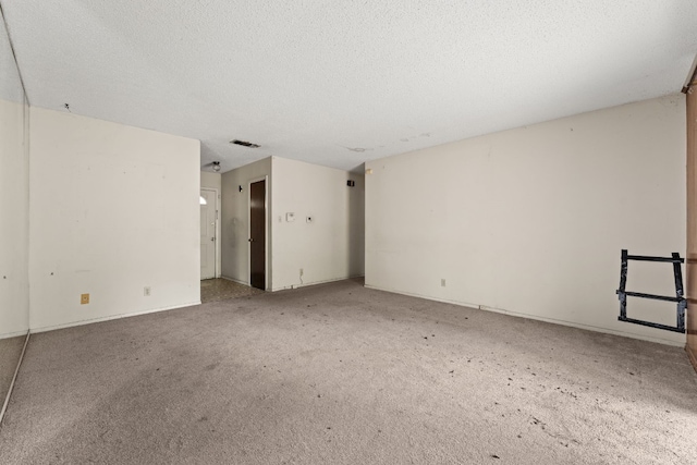 carpeted spare room with a textured ceiling