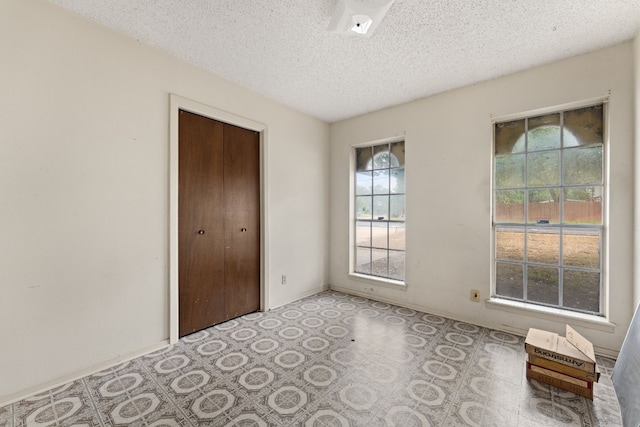 unfurnished bedroom featuring a textured ceiling and a closet