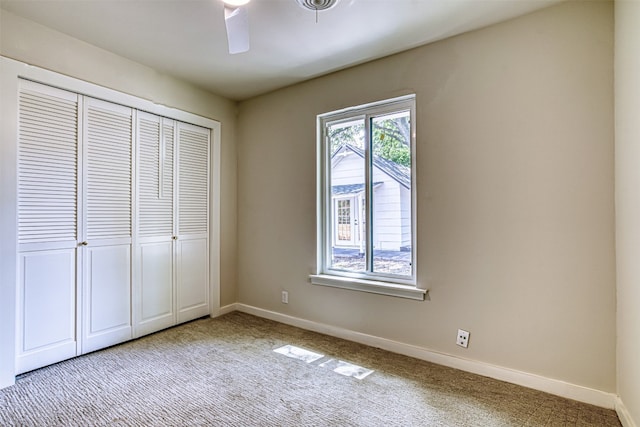 unfurnished bedroom featuring light carpet, ceiling fan, and a closet