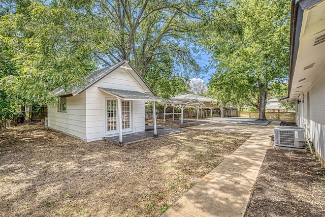 view of yard featuring central AC unit, a patio, and an outdoor structure