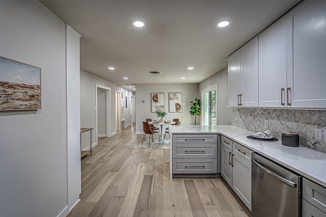 kitchen with dishwasher, light hardwood / wood-style floors, hanging light fixtures, kitchen peninsula, and decorative backsplash