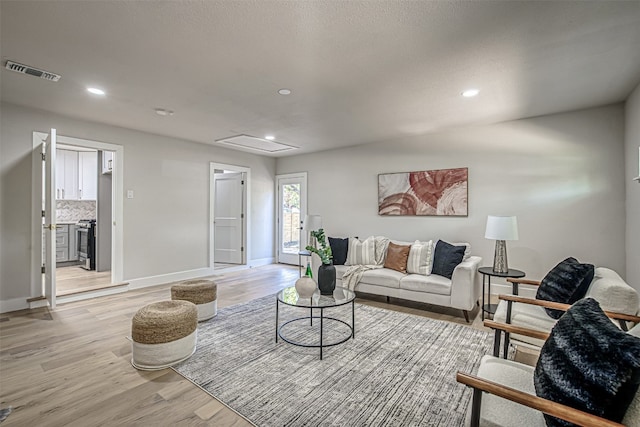 living room featuring a textured ceiling and light hardwood / wood-style flooring