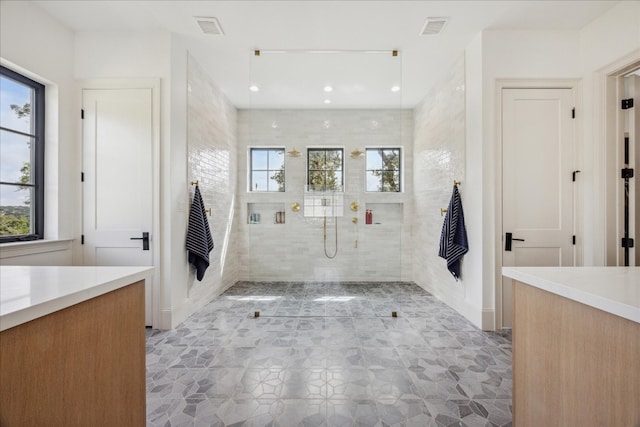 bathroom featuring vanity, a wealth of natural light, and a shower with shower door