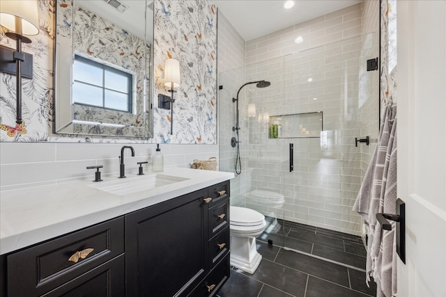 bathroom with walk in shower, toilet, tile walls, vanity, and tile patterned flooring