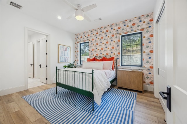 bedroom with radiator heating unit, ceiling fan, and light hardwood / wood-style flooring