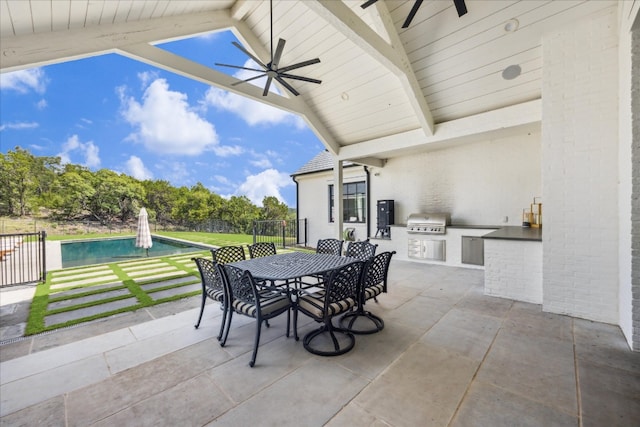 view of patio with a fenced in pool, grilling area, ceiling fan, and an outdoor kitchen