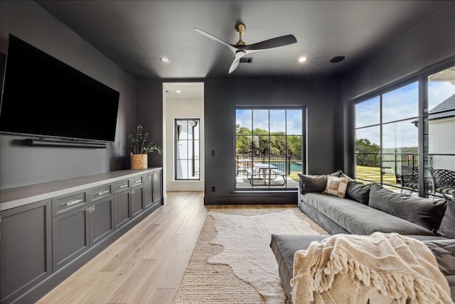 living room featuring ceiling fan and light hardwood / wood-style floors