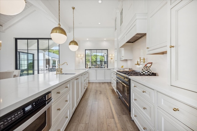 kitchen featuring decorative light fixtures, lofted ceiling with beams, sink, white cabinets, and double oven range