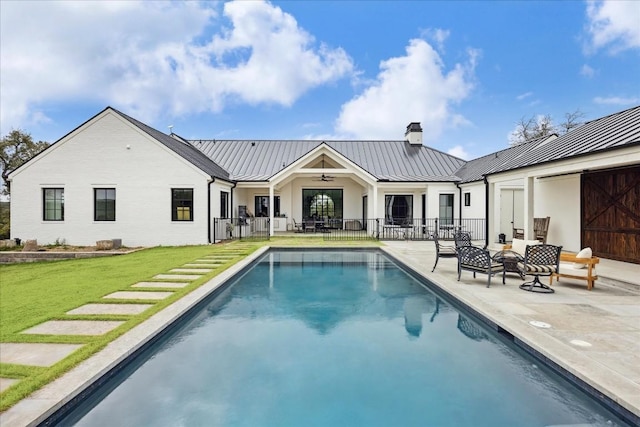 view of pool with ceiling fan, a yard, and a patio area