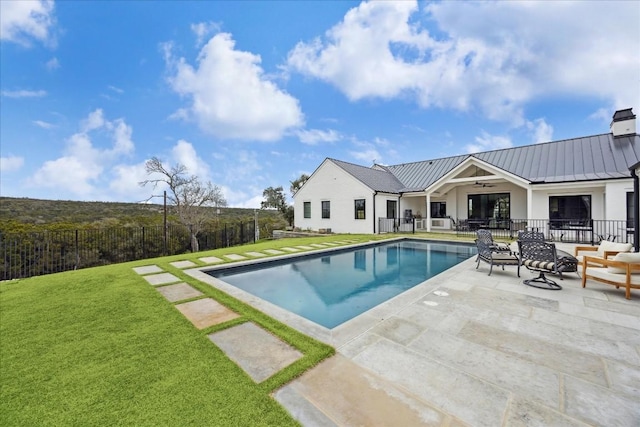 view of swimming pool featuring ceiling fan, a patio area, and a lawn