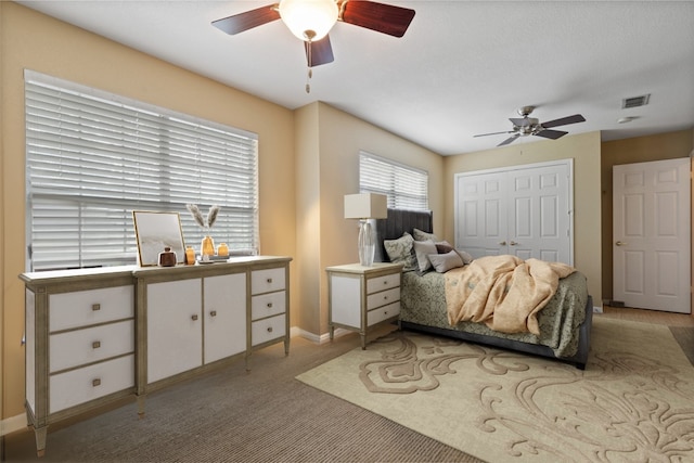 bedroom with light colored carpet, a closet, and ceiling fan