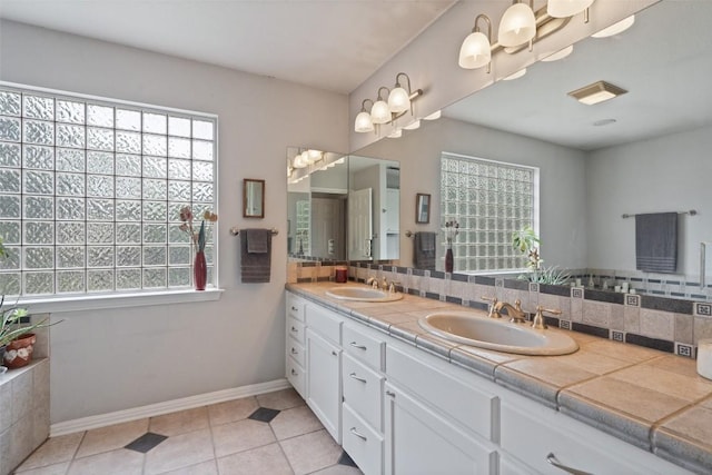 bathroom with tasteful backsplash, vanity, and tile patterned flooring