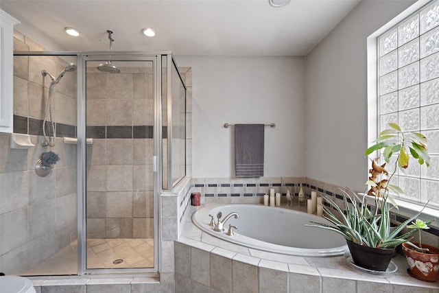 bathroom featuring shower with separate bathtub