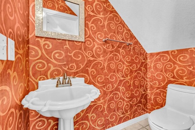 bathroom featuring lofted ceiling, a textured ceiling, tile patterned floors, and toilet