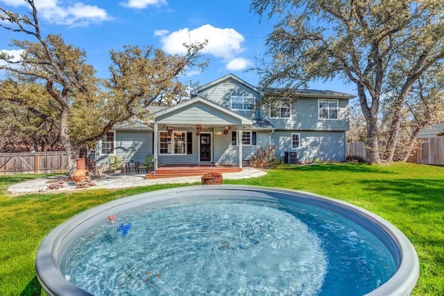 back of property featuring a lawn and a deck