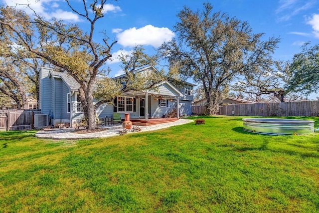 rear view of house with a yard, cooling unit, and a patio area