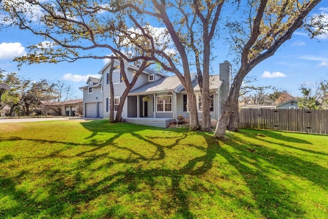 back of house featuring a garage and a lawn