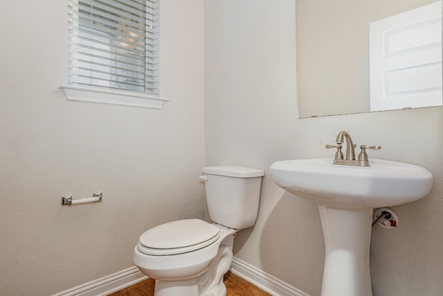 bathroom with toilet and hardwood / wood-style floors