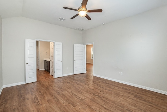 unfurnished bedroom featuring vaulted ceiling, connected bathroom, ceiling fan, and dark hardwood / wood-style floors