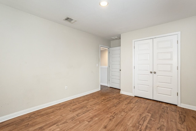 unfurnished bedroom featuring hardwood / wood-style floors and a closet