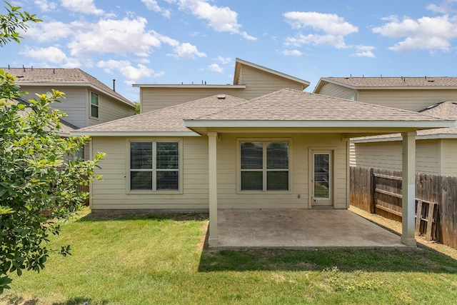 back of property with a lawn and a patio