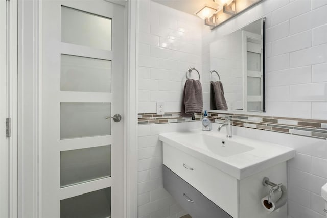 bathroom featuring vanity, tile walls, and backsplash