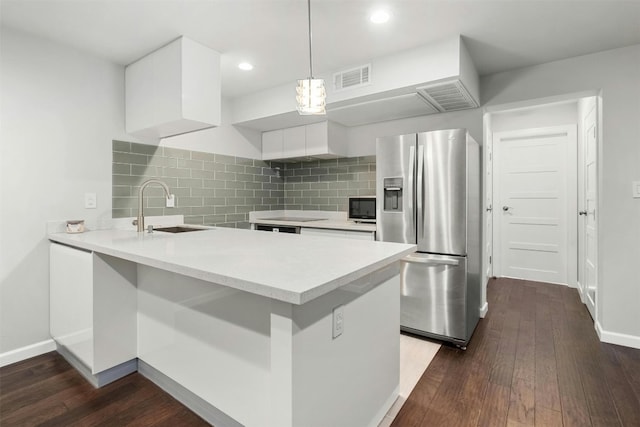 kitchen featuring pendant lighting, stainless steel fridge, white cabinetry, sink, and dark hardwood / wood-style floors