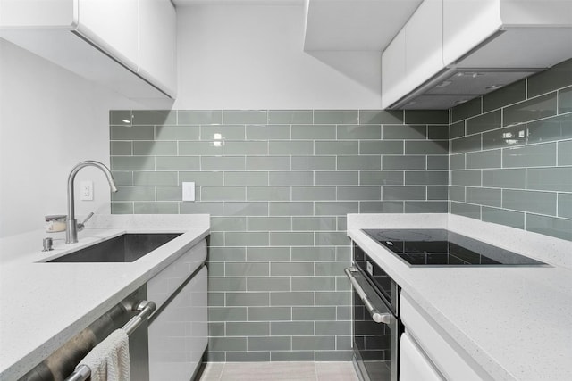 kitchen featuring light stone countertops, sink, ventilation hood, stainless steel oven, and white cabinetry