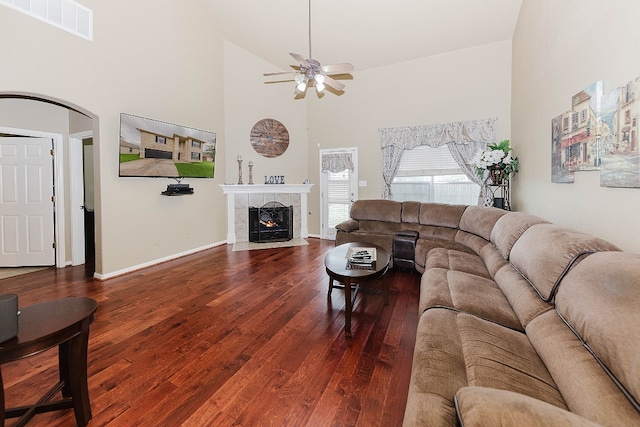 living room with a tiled fireplace, ceiling fan, high vaulted ceiling, and hardwood / wood-style flooring