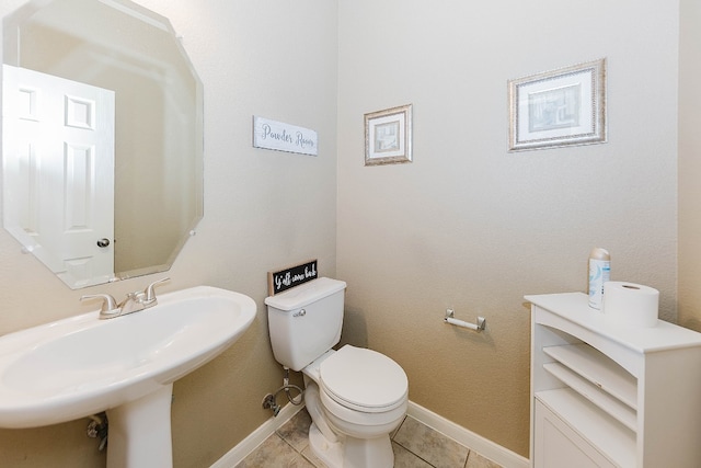 bathroom featuring toilet, tile patterned floors, and sink