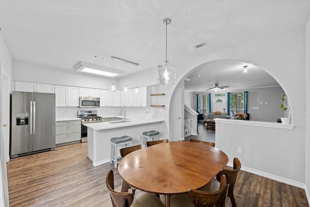 dining space featuring light hardwood / wood-style flooring, ceiling fan, and sink