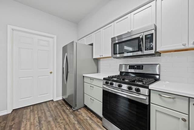 kitchen featuring white cabinets, appliances with stainless steel finishes, dark hardwood / wood-style flooring, and tasteful backsplash