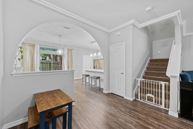 interior space featuring crown molding, an inviting chandelier, and dark hardwood / wood-style floors