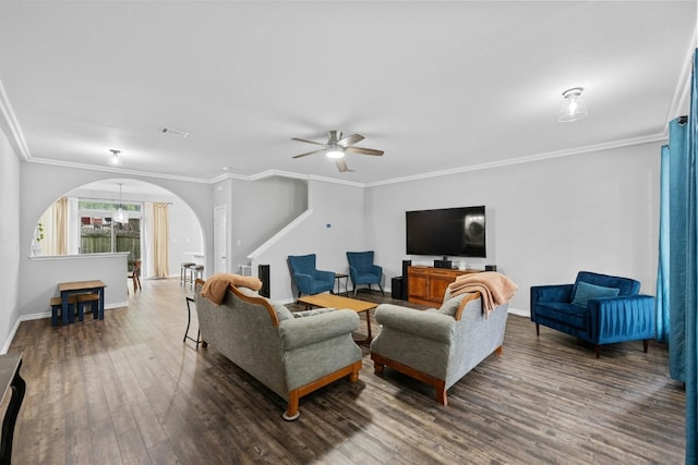 living room with ornamental molding, dark wood-type flooring, and ceiling fan