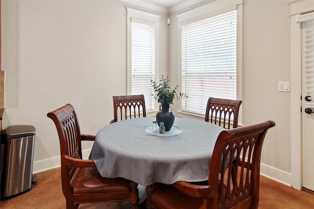 carpeted dining area featuring baseboards