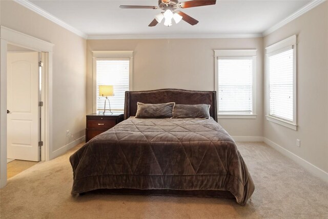 bedroom featuring ceiling fan, baseboards, crown molding, and light colored carpet