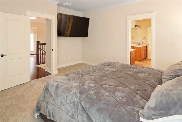 bedroom with ensuite bath, ornamental molding, and carpet flooring