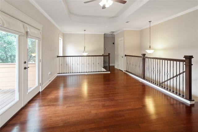 spare room featuring ceiling fan, ornamental molding, a tray ceiling, and dark hardwood / wood-style flooring