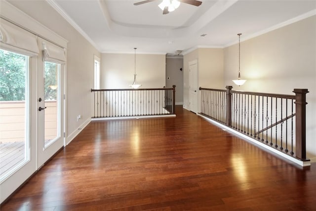 spare room featuring crown molding, a ceiling fan, a raised ceiling, and wood finished floors