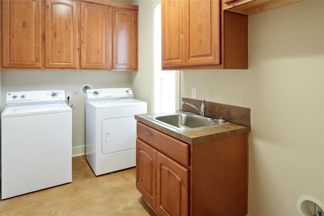 clothes washing area featuring washer and dryer, cabinets, and sink