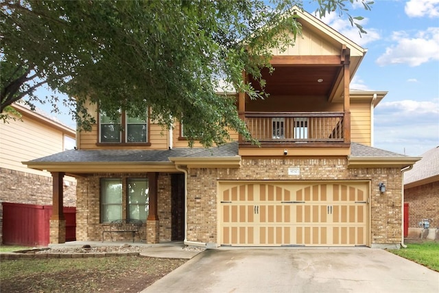 view of front of house with concrete driveway, brick siding, a shingled roof, and a balcony