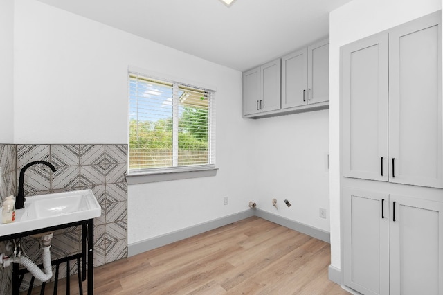 washroom featuring cabinets, light hardwood / wood-style flooring, and sink