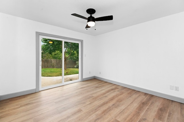 empty room with ceiling fan and light hardwood / wood-style flooring