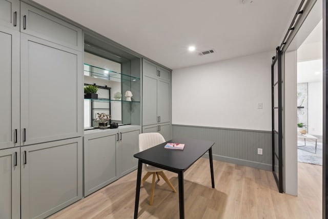 office featuring light hardwood / wood-style floors and a barn door