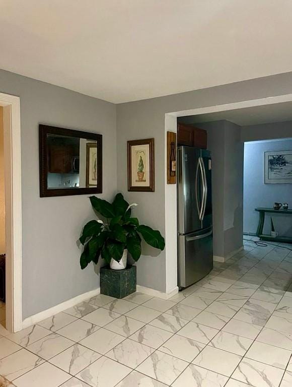 interior space with baseboards and marble finish floor