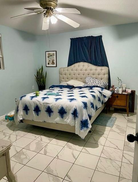 bedroom with marble finish floor, baseboards, and a ceiling fan
