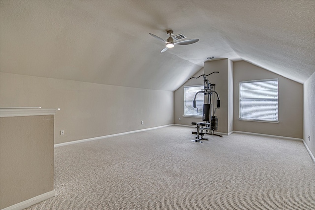 additional living space featuring ceiling fan, lofted ceiling, light carpet, and a textured ceiling